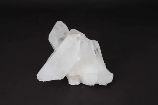Clear Quartz Cluster on a dark background, showcasing multiple crystal points that purify energy and amplify intention.