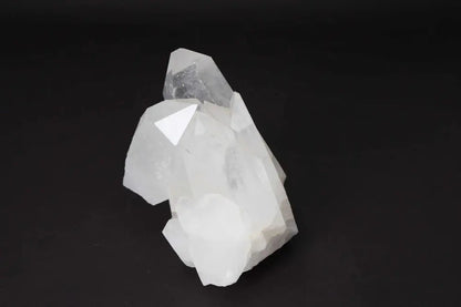 Clear Quartz Cluster radiating energy and clarity, featuring multiple crystal points on a dark background, ideal for energy cleansing.