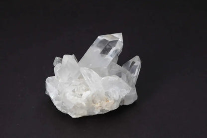 Clear Quartz Cluster on black background, showcasing multiple crystal points and natural formation; radiates purity and energy amplification.