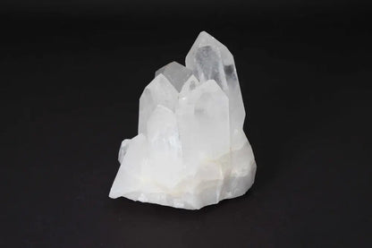 Clear quartz cluster on black background, featuring multiple crystal points for energy amplification and purification.