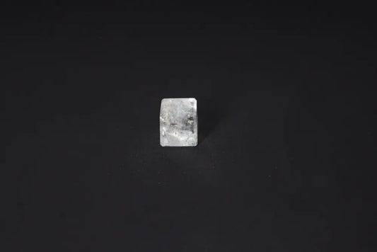 Clear Quartz Cube 2.5 cm on black background, known for purification and neutralizing negative vibrations and electromagnetic radiation.