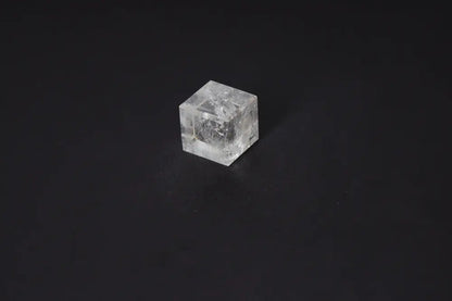 Clear Quartz Cube 3.5 cm on dark background, used for purification and harmonizing energy, dispelling negative thoughts and emotions.