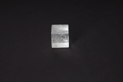 Clear Quartz Cube 4cm on dark background, known for purification and neutralizing negative vibrations. Ideal for harmonizing body, mind, energy.