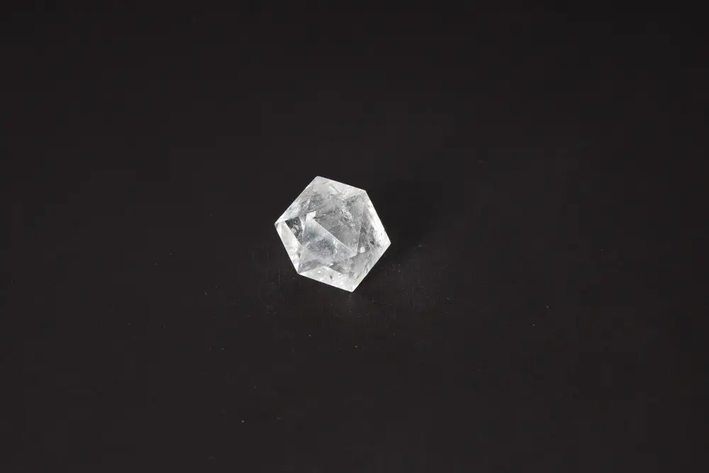 Clear Quartz Geometric Sphere 3 cm on black background, used for harmonizing body and mind, absorbing negative energy, and electromagnetic neutralization.