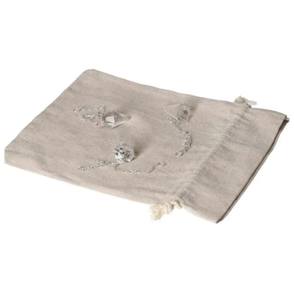 Clear Quartz Pendulum on linen pouch, harmonizes energy and purifies space, ideal for daily use.