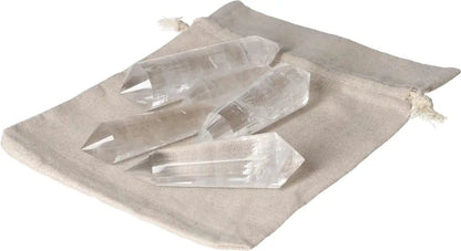 Five Clear Quartz points on a beige fabric pouch, known for purification and harmonizing body, mind, and energy.