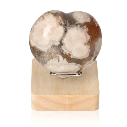 Flower Agate Heart gemstone on wooden stand, showcasing natural elegance and spiritual tranquility for peace and balance.