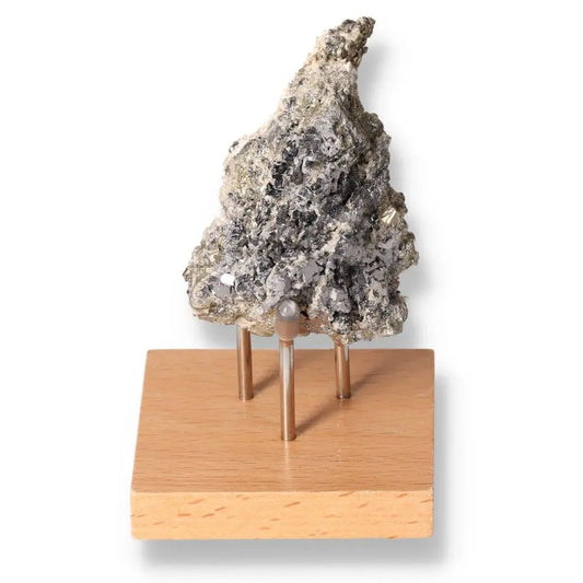 Galena stone on wooden stand showcasing its transformative and grounding properties, linking spiritual and physical realms.