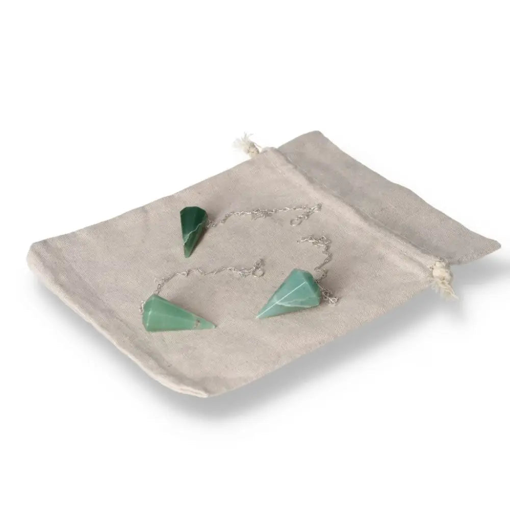 Green quartz pendulum set with chain on a beige cloth bag, ideal for dowsing and energy work.