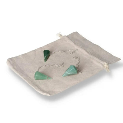 Green quartz pendulum set with chain on a beige cloth bag, ideal for dowsing and energy work.
