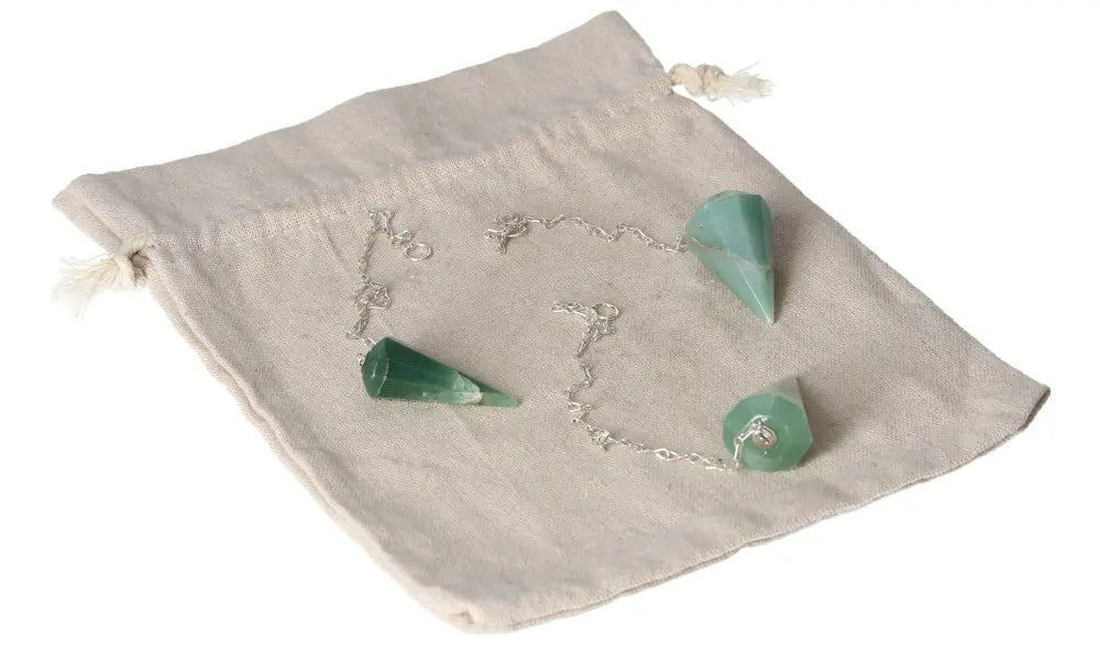Green quartz pendulum on fabric pouch, showcasing gemstone pendant with chain.