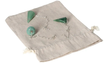 Green quartz pendulums on a beige pouch, showcasing their unique facets and chain for divination or meditation purposes.