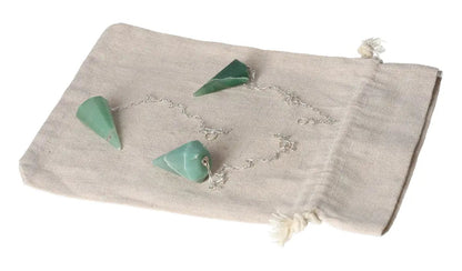 Green quartz pendulum with chain displayed on a beige cloth pouch.