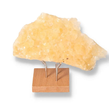 Honey Calcite gemstone on stand, known for boosting confidence and clarity, aligns with solar plexus and sacral chakras.