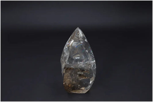 Large Lemurian Quartz Obelisk on dark background, highlighting its clear, natural crystalline structure and ethereal beauty.
