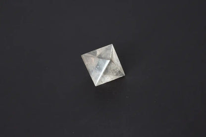 Lemurian Quartz Double Pyramid 3 cm displaying sacred geometry against a dark background, highlighting its ethereal clarity and striations.