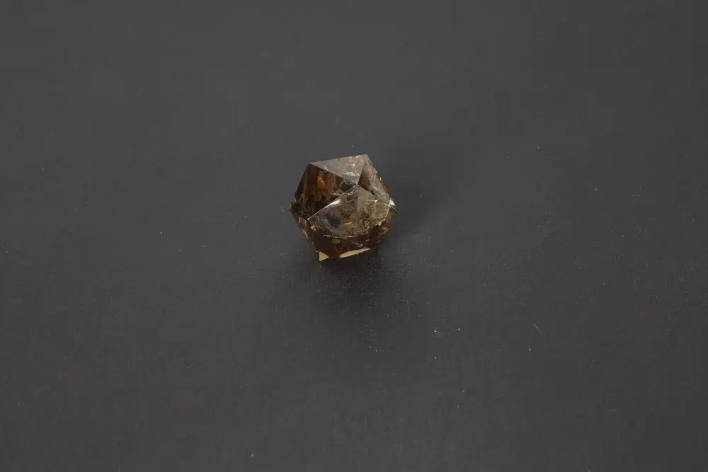 Smoky quartz dodecahedron gemstone on black background