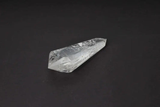Lemurian Quartz Point with distinct striations, believed to carry Lemurian wisdom and ancient energies, displayed on a dark background.
