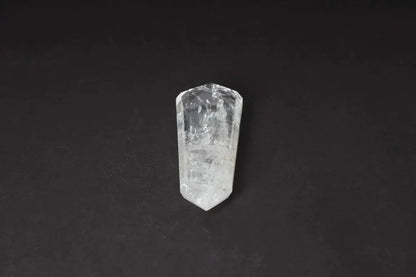 Lemurian Quartz Point crystal with horizontal striations, believed to hold ancient Lemurian wisdom, on a dark background.