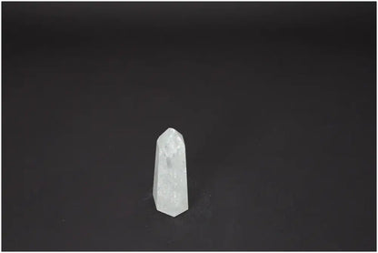 Lemurian Quartz Obelisk on dark background, showcasing its clarity and unique spiritual properties.
