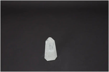 Clear Lemurian Quartz obelisk with unique properties for chakra and zodiac energy alignment against a dark background.