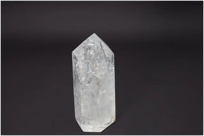 Lemurian Quartz Obelisk against dark background, enhancing chakras and spiritual energy with unique quartz properties.