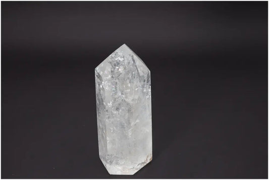 Lemurian Quartz Obelisk against dark background, enhancing chakras and spiritual energy with unique quartz properties.