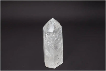 Clear Lemurian Quartz Obelisk standing against a black background, showcasing unique crystal clarity and energetic properties.