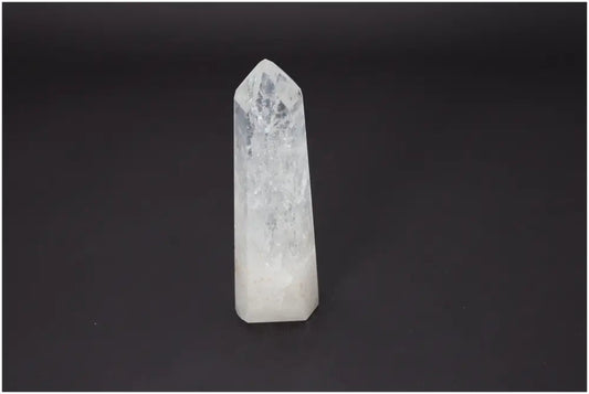 Lemurian Quartz Obelisk with healing properties, supporting chakras and zodiac signs, on a dark background.