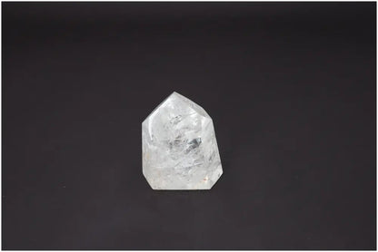 Lemurian Quartz Obelisk against dark background, unique crystal with energetic properties for chakra alignment and spiritual support.