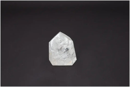 Lemurian Quartz Obelisk against dark background, unique crystal with energetic properties for chakra alignment and spiritual support.
