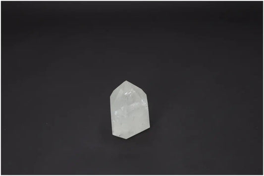 Lemurian Quartz Obelisk with spiritual properties on a dark background, supporting chakras and zodiac signs.