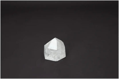Polished Lemurian Quartz Obelisk on dark background, highlighting energetic properties linked with chakras and zodiac signs.