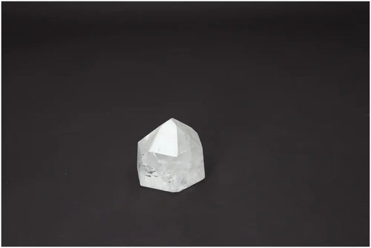 Polished Lemurian Quartz Obelisk on dark background, highlighting energetic properties linked with chakras and zodiac signs.