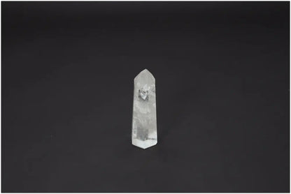 Lemurian Quartz Obelisk against dark background, featuring natural clarity and spiritual properties, linked to chakras and zodiac signs.