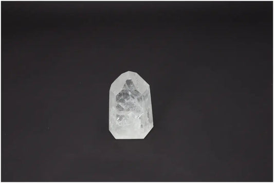 Lemurian Quartz Obelisk against a dark background, known for its spiritual properties and chakra alignment.