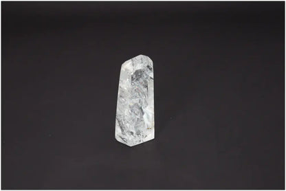 Lemurian Quartz Obelisk with varied quartz properties, aligning chakras and supporting spiritual needs against a dark background.