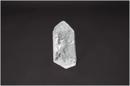 Lemurian Quartz Obelisk on a dark background, showcasing clear crystal structure with spiritual and energetic chakra properties.