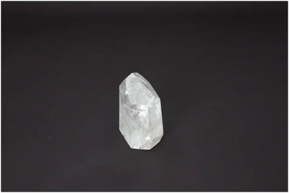 Lemurian Quartz Obelisk with unique properties enhancing chakra alignment and spiritual energy, clear crystal on a dark background.