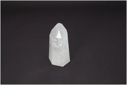 Lemurian Quartz Obelisk on dark background, showcasing unique properties for chakras and zodiac alignment.
