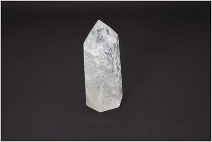 Clear Lemurian quartz obelisk for chakra alignment and spiritual enhancement on a dark background.