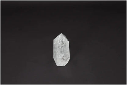 Lemurian Quartz Obelisk crystal on dark background, known for clarity and energy amplification.