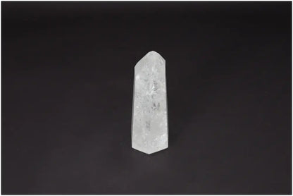 Lemurian Quartz Obelisk on dark background, embodies clarity and balance, ethically sourced clear quartz for personal growth.