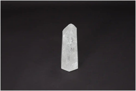 Lemurian Quartz Obelisk on dark background, embodies clarity and balance, ethically sourced clear quartz for personal growth.