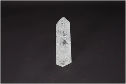 Lemurian Quartz Obelisk crystal standing against a dark background, known for clarity, balance, and personal growth enhancement.