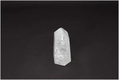 Lemurian Quartz Obelisk on black background, a clear crystal known for clarity and energy amplification, ethically sourced and hand-selected.