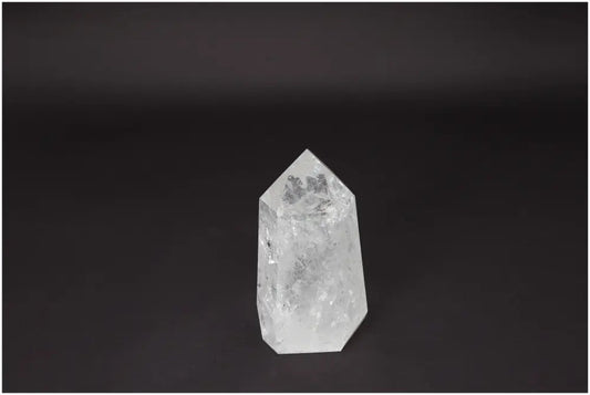 Lemurian Quartz Obelisk on black background, clear crystal known for clarity, balance, and personal growth, ethically sourced and hand-selected.