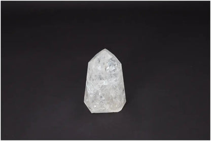Lemurian Quartz Obelisk crystal against a dark background, known for its clarity-enhancing and energy-amplifying properties.