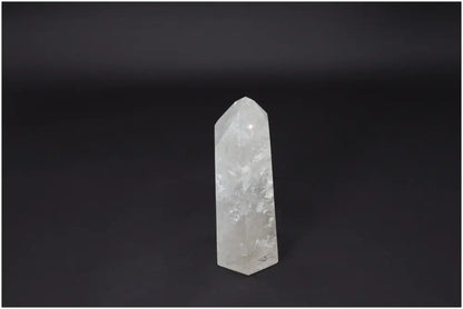 Lemurian Quartz Obelisk, a clear crystal known for clarity and healing, stands on a dark background, enhancing energy and balance.