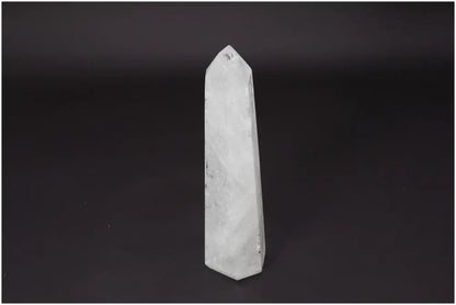Lemurian Quartz Obelisk on black background, clear crystal known for enhancing clarity and personal growth, ethically sourced and natural.